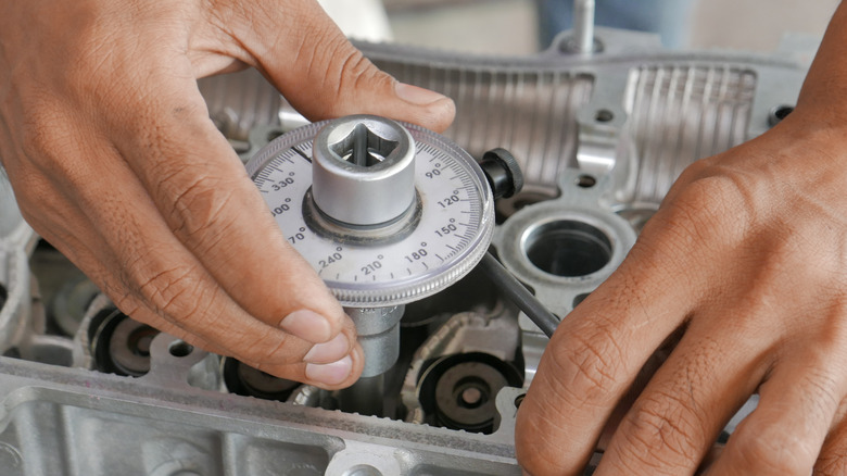 Technician tolerancing an engine head during remanufacturing