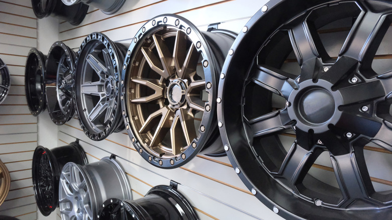 Various metal rims hanging on a white wooden wall