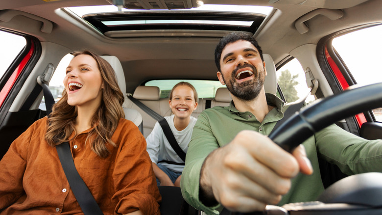 A family heading out on a road trip in a car