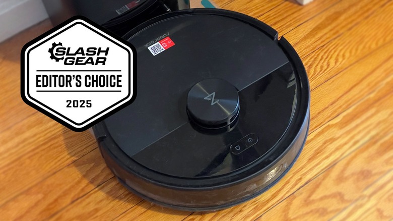 The Roborock Q7 M5+ vacuuming along the wall on a wooden floor.