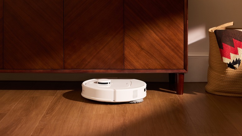 The Roborock QV 35A in white navigating under furniture