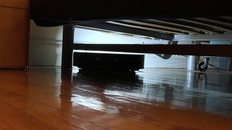 Mova V50 Ultra Complete cleaning under a couch with its top sensor retracted.