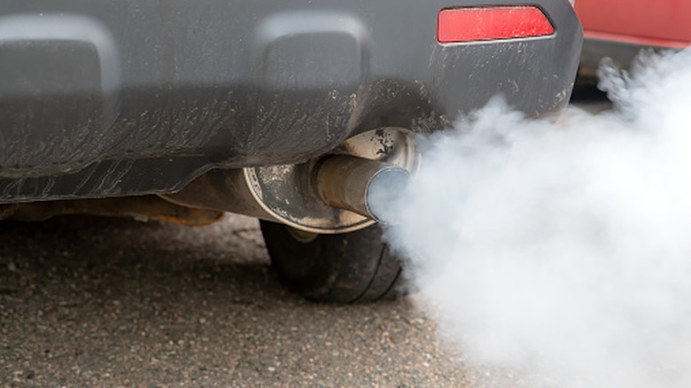 Close up of a car tailpipe spewing emissions.