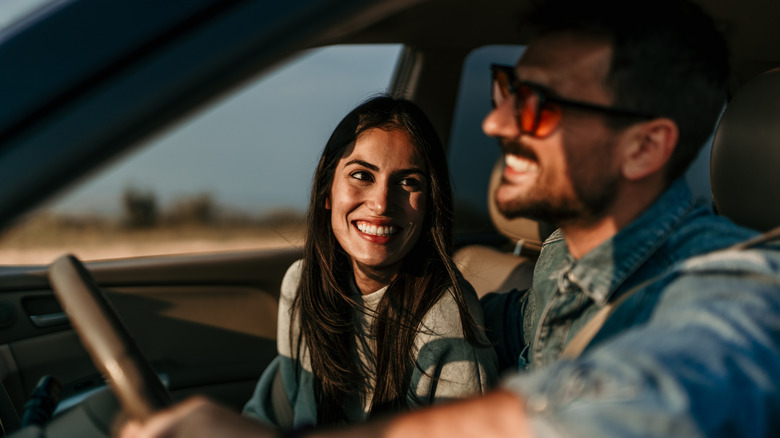 Happy couple smiling in car.