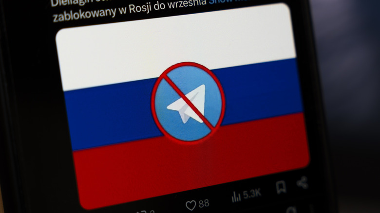 Image of a phone screen showing the Russian flag with a crossed-out Telegram logo over it.