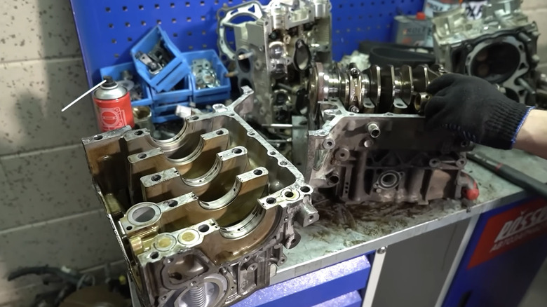 View of the Garage 54 mechanics working on the block of a modified Subaru boxer engine.