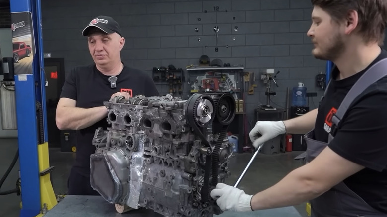 View of Garage 54 mechanics showing their custom built Subaru inline-four engine.