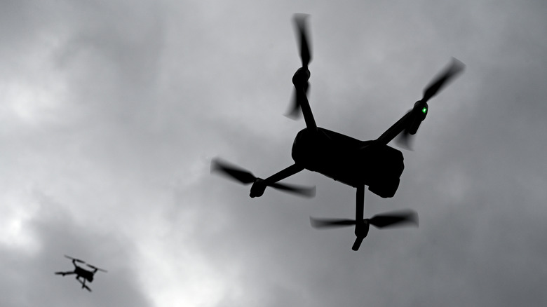 Two drones flying under cloudy skies