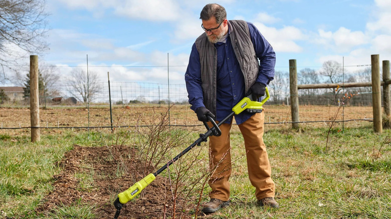 Worker using a Ryobi 18 ONE+ Garden Hoe on a farm