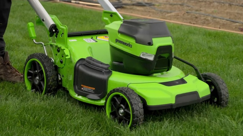 A Greenworks lawn mower on grass.