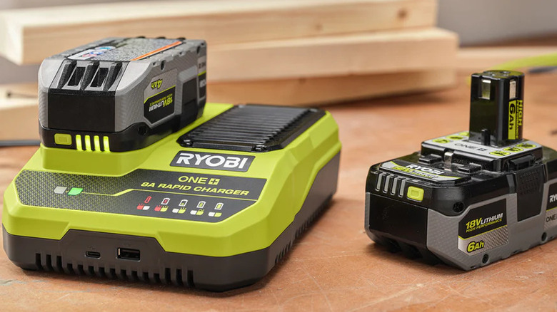 the Ryobi 8A Rapid Charger and some batteries on lumber