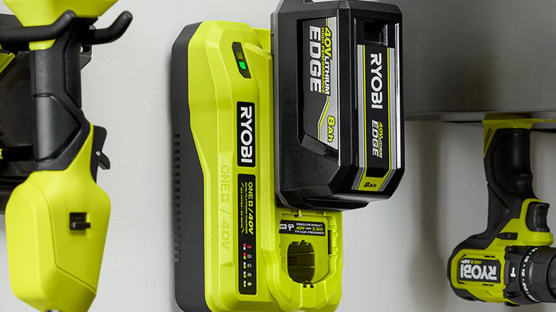 The Ryobi 18V/40V Dual Platform Charger mounted on a wall with other tools nearby