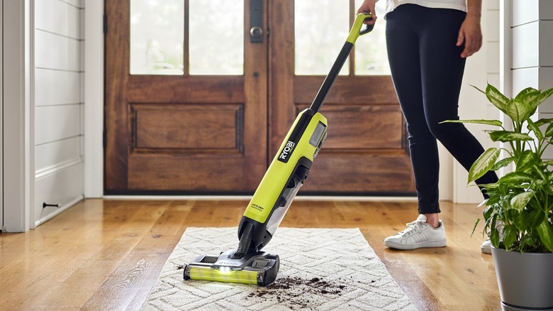 Person vacuuming dirt off of a rug