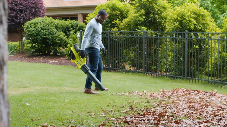 Person using Ryobi blower on leaves