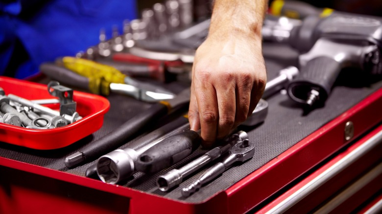 hand reaching in toolbox