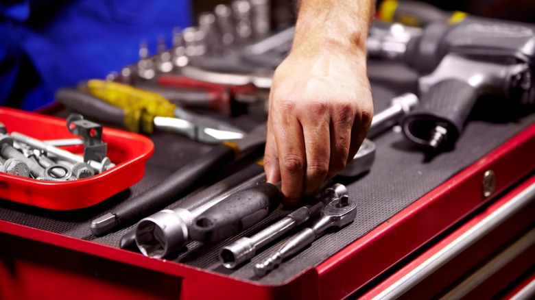 hand reaching in toolbox