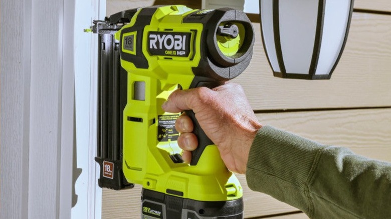 Person using brand nailer on door frame