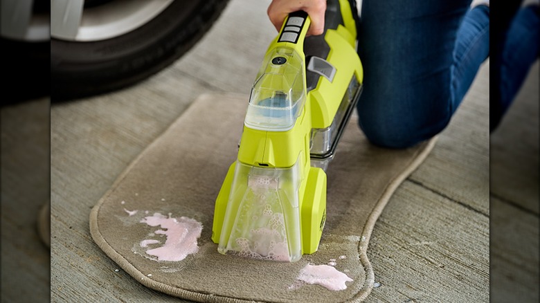 person using ryobi spot cleaner