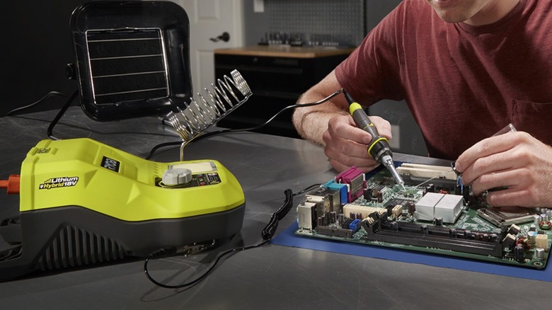 Person soldering a motherboard together