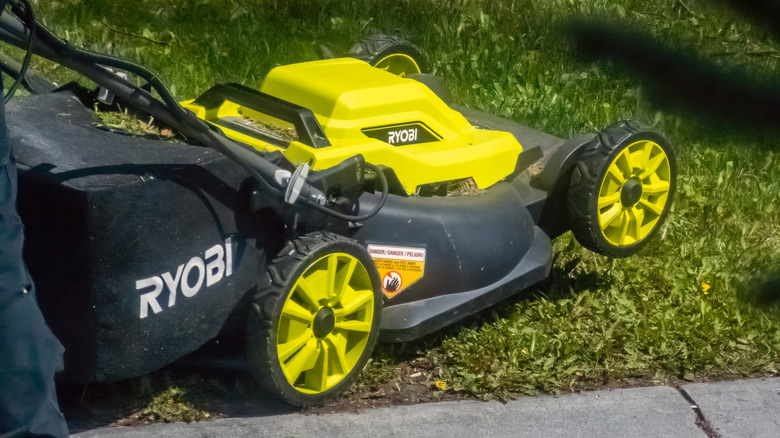 Ryobi battery powered push lawn mower being placed on a lawn