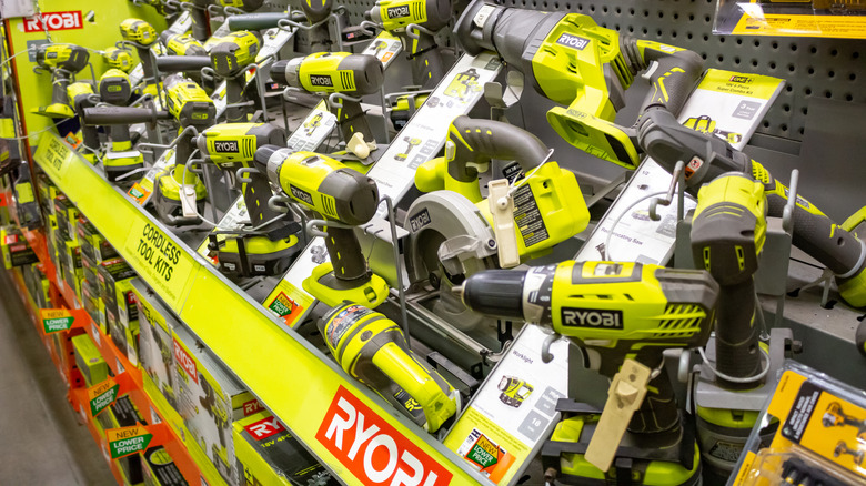 A large selection of Ryobi power tools on display in a store