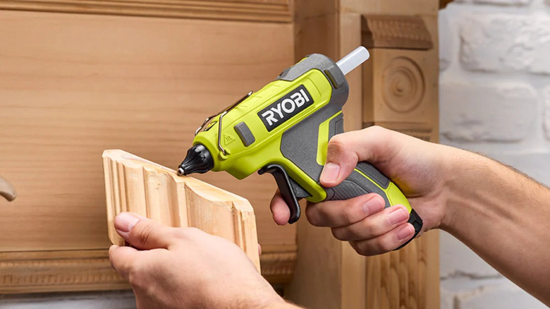 Ryobi USB Lithium Glue Gun dispensing glue stick on wooden piece