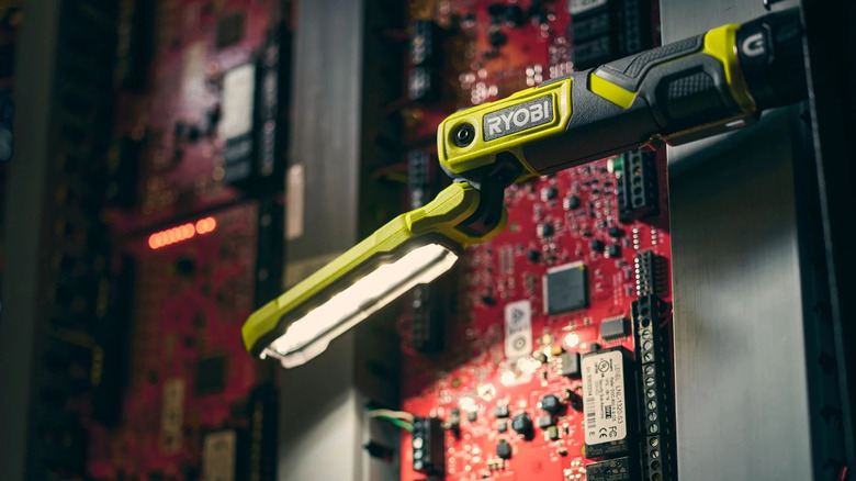 Ryobi USB Lithium magnetic inspection light attached to a metal panel lighting up circuit boards