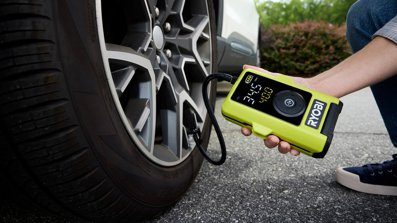 Close-up of person using a Ryobi USB Lithium smart tire inflator