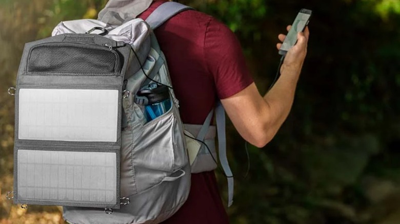 man with Ryobi solar panel on backpack