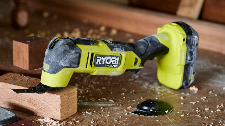 Ryobi 18V One+ HP Brushless Oscillating Multi-Tool leaning on piece of wood