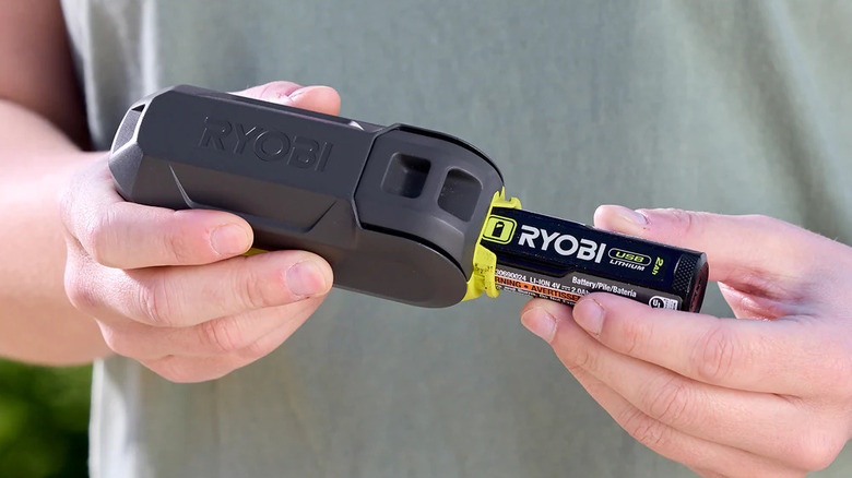 A woman putting battery into a Ryobi Fan