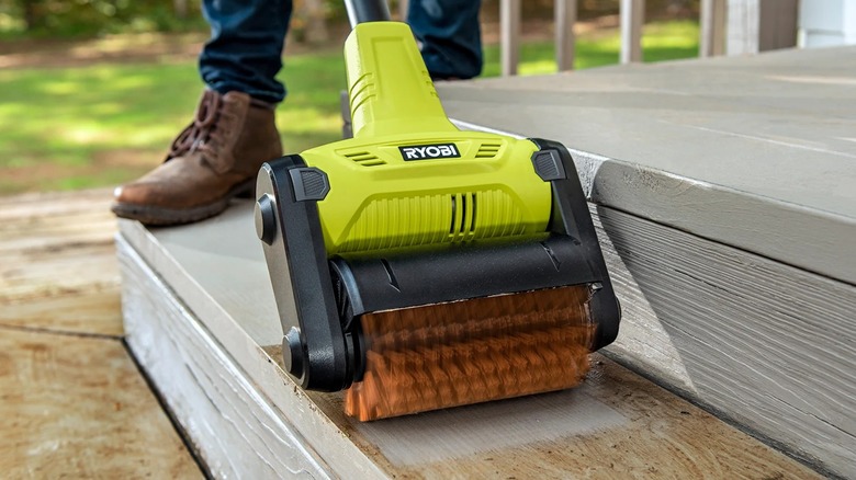 A person using a Ryobi patio cleaner.