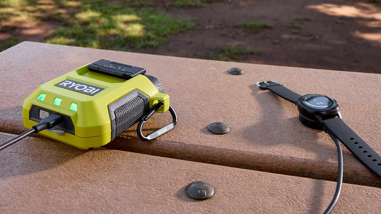 A smartwatch connected to a Ryobi USB Lithium Battery charger