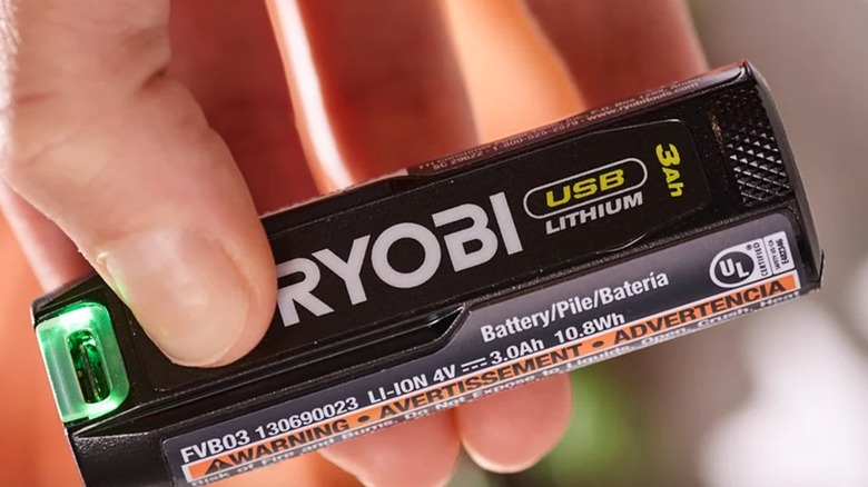 A person holding a Ryobi USB Lithium with green light