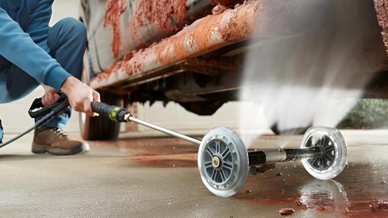 Cleaning under car with water broom