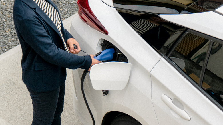 Woman charging white EV