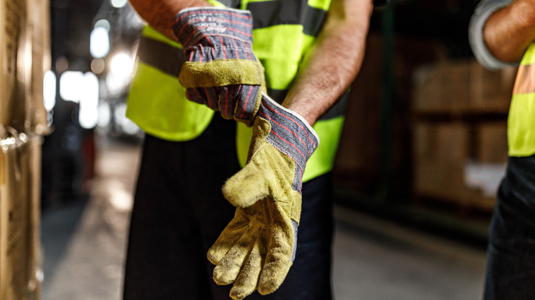 Worker putting on protective gloves