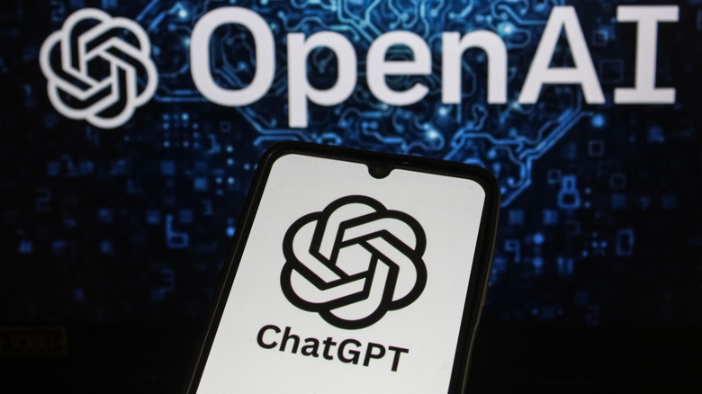 ChatGPT logo appears on a mobile phone with OPEN AI visible in the background.