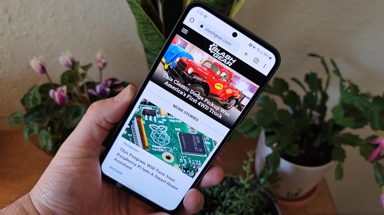 Samsung Galaxy A54 being held in front of plants