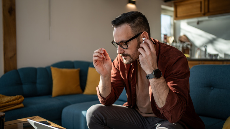 Man using wireless earbuds with computer