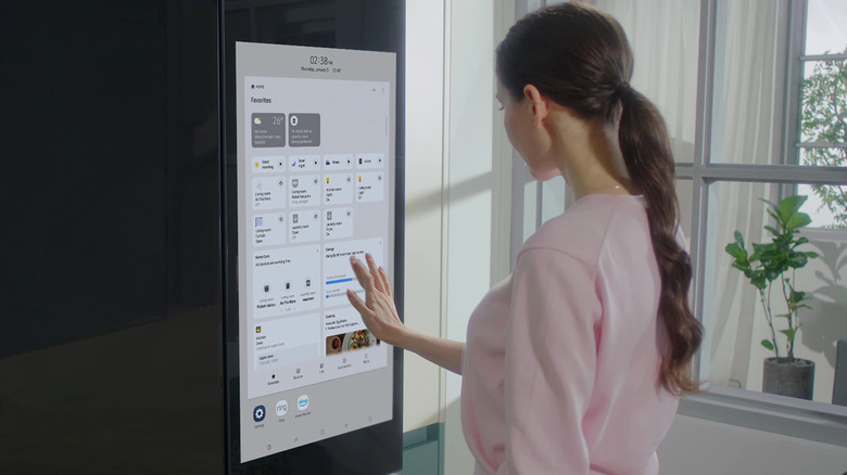 Woman using touchscreen on Samsung Family Hub fridge
