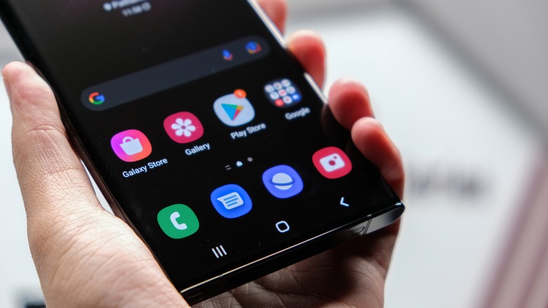 Apps displayed on Samsung Galaxy S22 held in hand