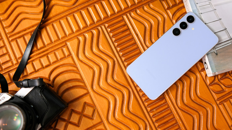 A digital camera and a Samsung smartphone on a surface