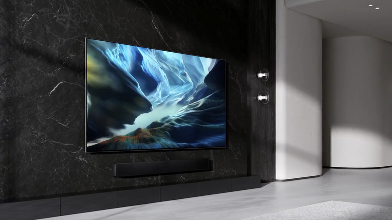 Samsung S90H TV mounted on wall in sleek modern room