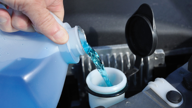 Pouring windshield wiper fluid in reservoir