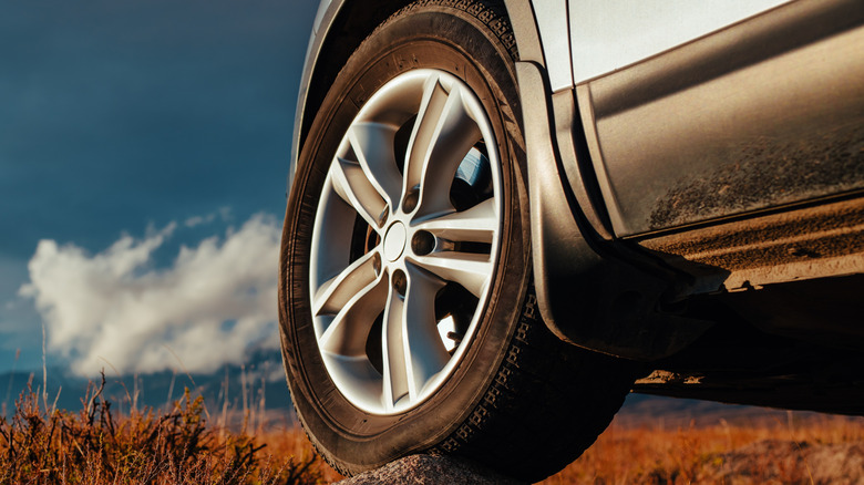 A car tire resting on a rock.