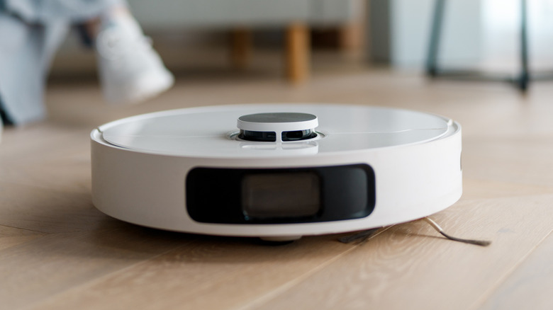 White robotic vacuum cleaner on wooden floor