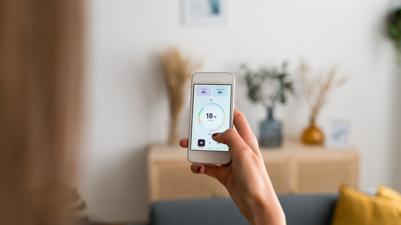 Person holding smartphone looking at a temperature app