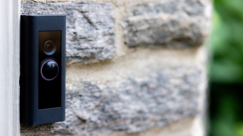 Black doorbell camera mounted on a brick wall
