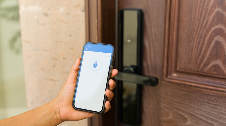 Hand holding a device displaying a lock icon